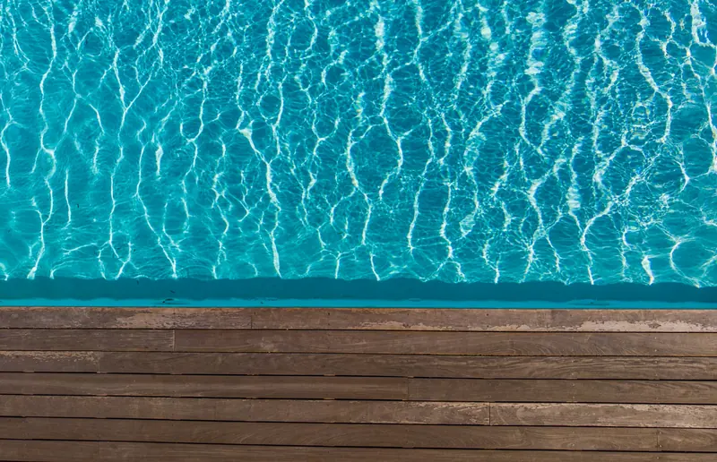 Poolkante mit angrenzendem Holzdeck von oben