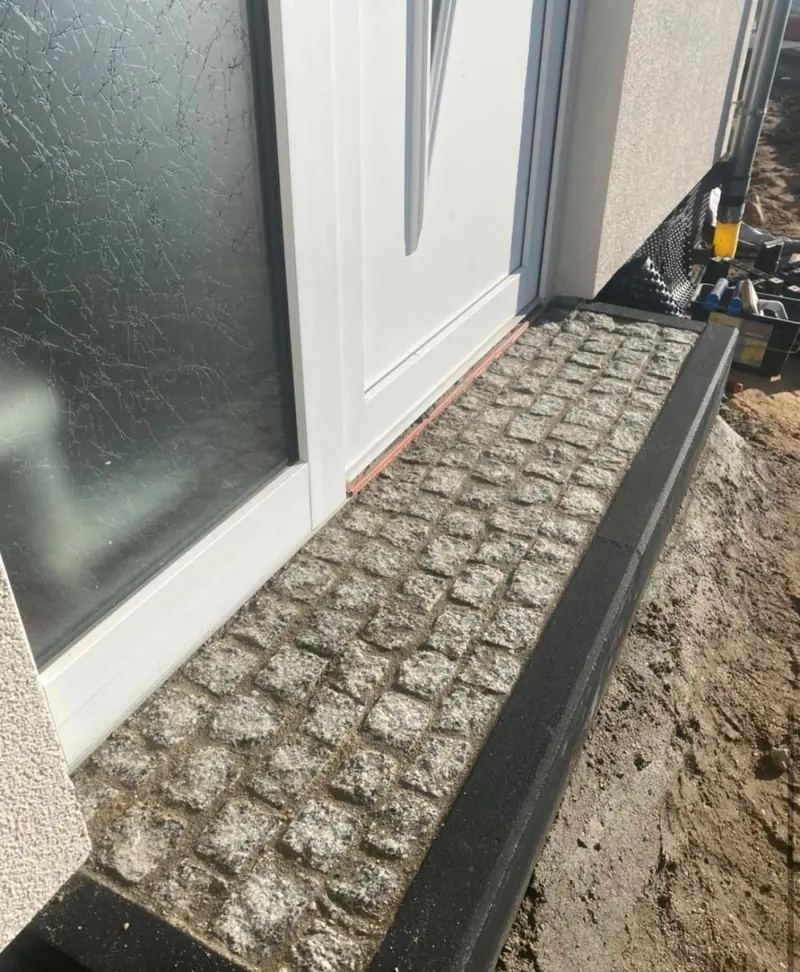 Fertiger Traufstreifen aus Granit mit Kantenstein vor der Hauswand