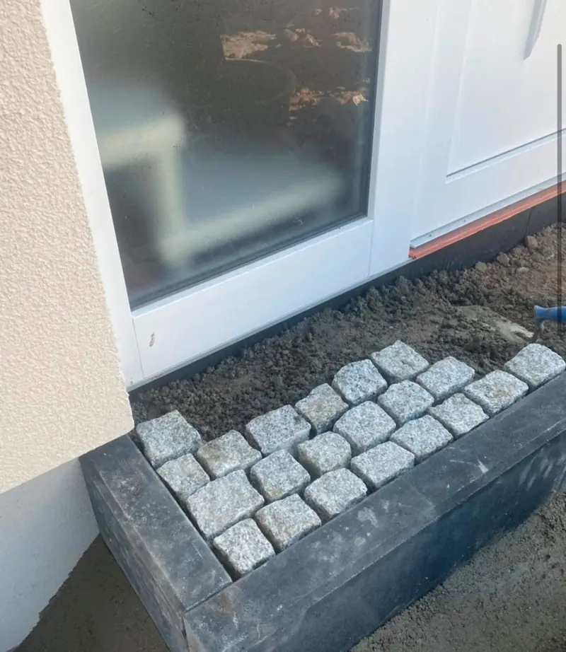 Traufstreifen aus Granit-Kleinpflaster vor einer Terrassentür
